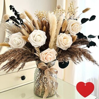 Rustic floral arrangement with pampas grass and white roses in a vase.