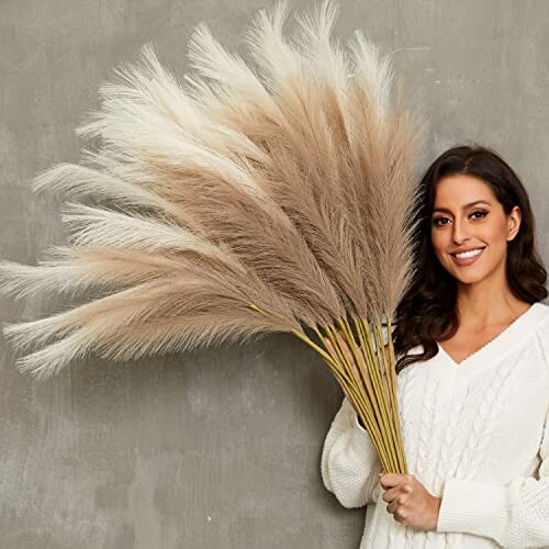 Woman holding a large bouquet of pampas grass.